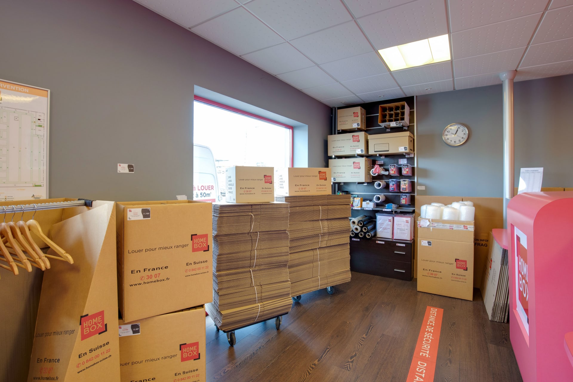Boutique intérieure avec cartons de déménagement empilés, housses et présentoirs de fournitures du centre HOMEBOX Le Havre