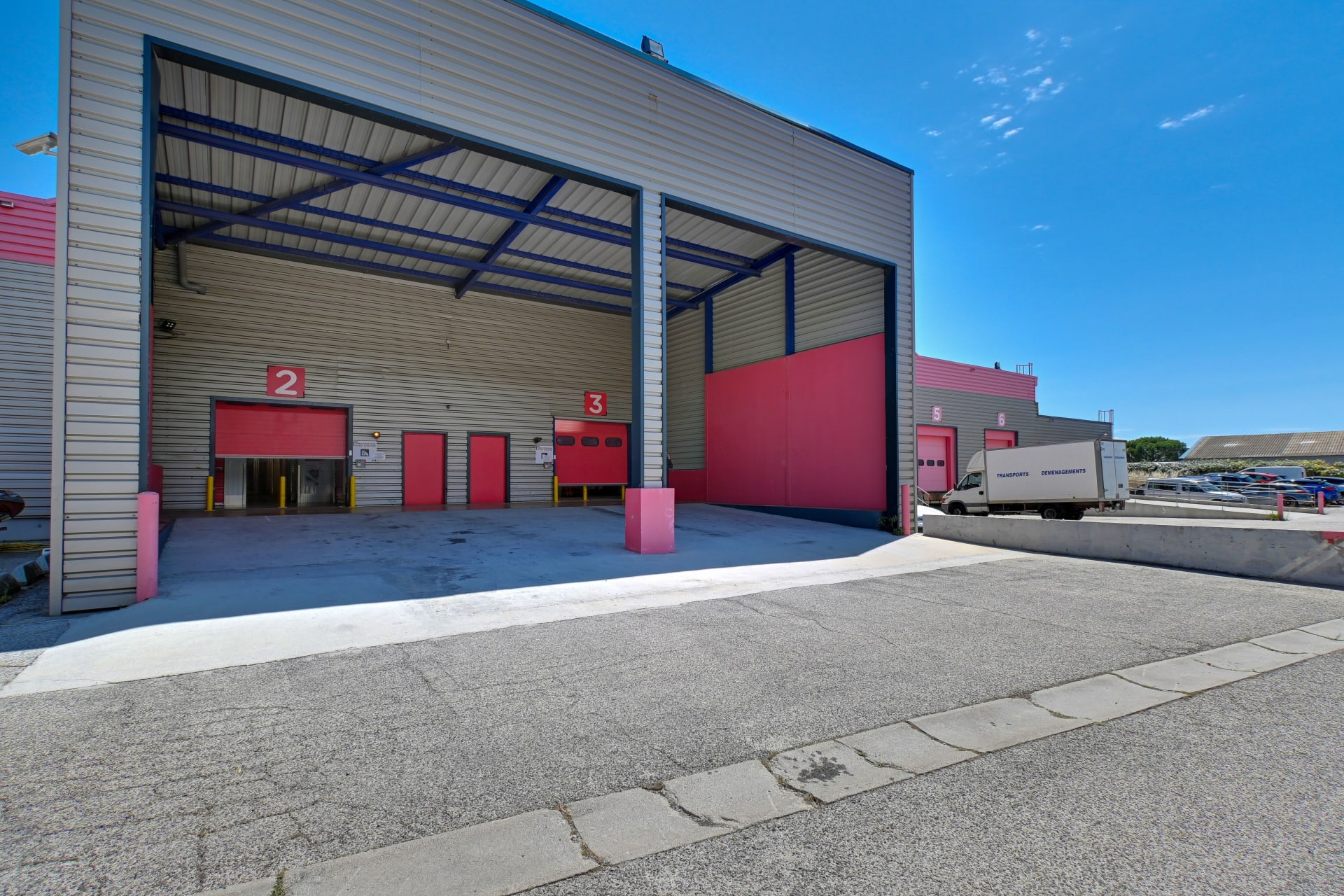Quais de chargement couverts avec portes rouges numérotées et camion stationné, HOMEBOX Toulon - La Farlède, 200 ancienne route de la Garde à La Farlède