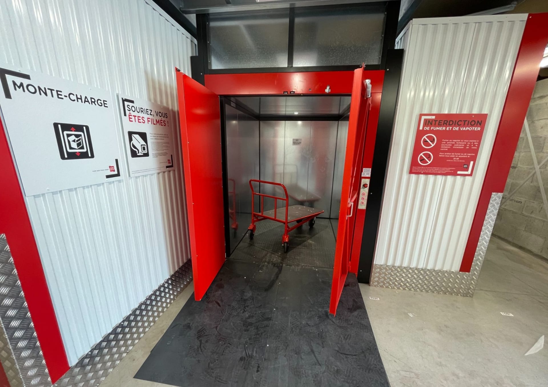 Monte-charge du centre HOMEBOX Albertville avec portes rouges ouvertes.