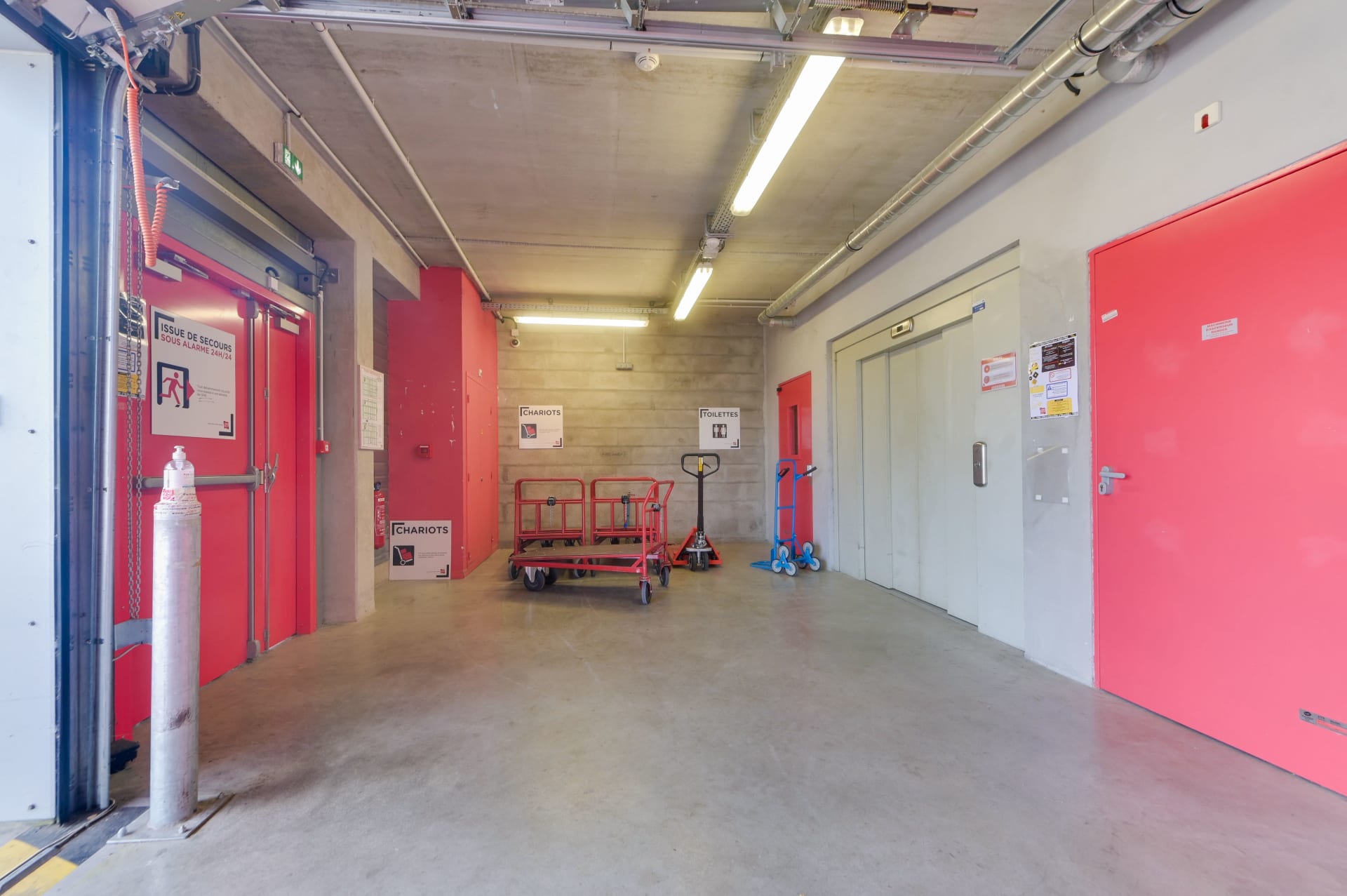 Zone de manutention intérieure avec chariots, transpalette et portes coupe-feu du centre HOMEBOX Pau