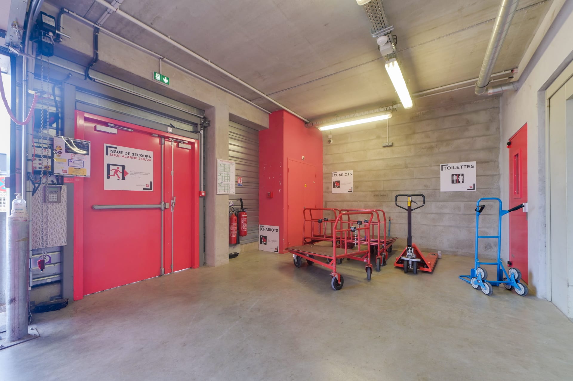 Espace de manutention avec chariots de transport et porte de secours du centre HOMEBOX Pau