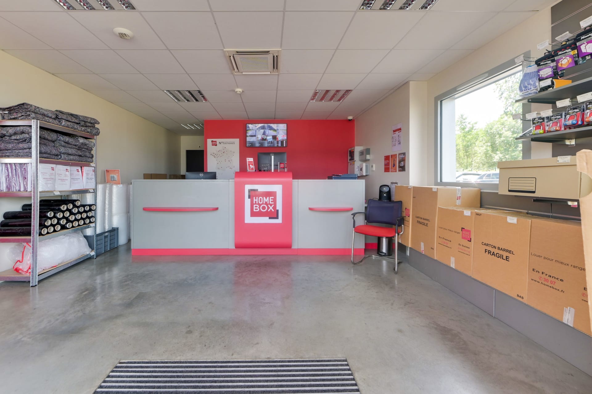 Comptoir d'accueil avec cartons de déménagement et présentoir de fournitures du centre HOMEBOX Pau