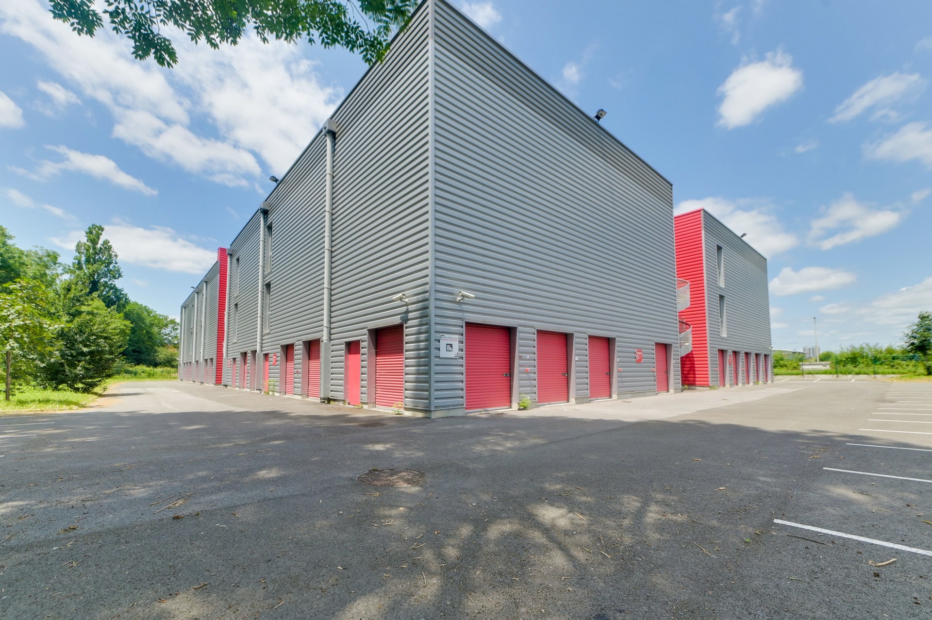 Bâtiment de stockage avec portes de boxes rouges en extérieur, HOMEBOX Pau, Chemin de la Saligue à Lons
