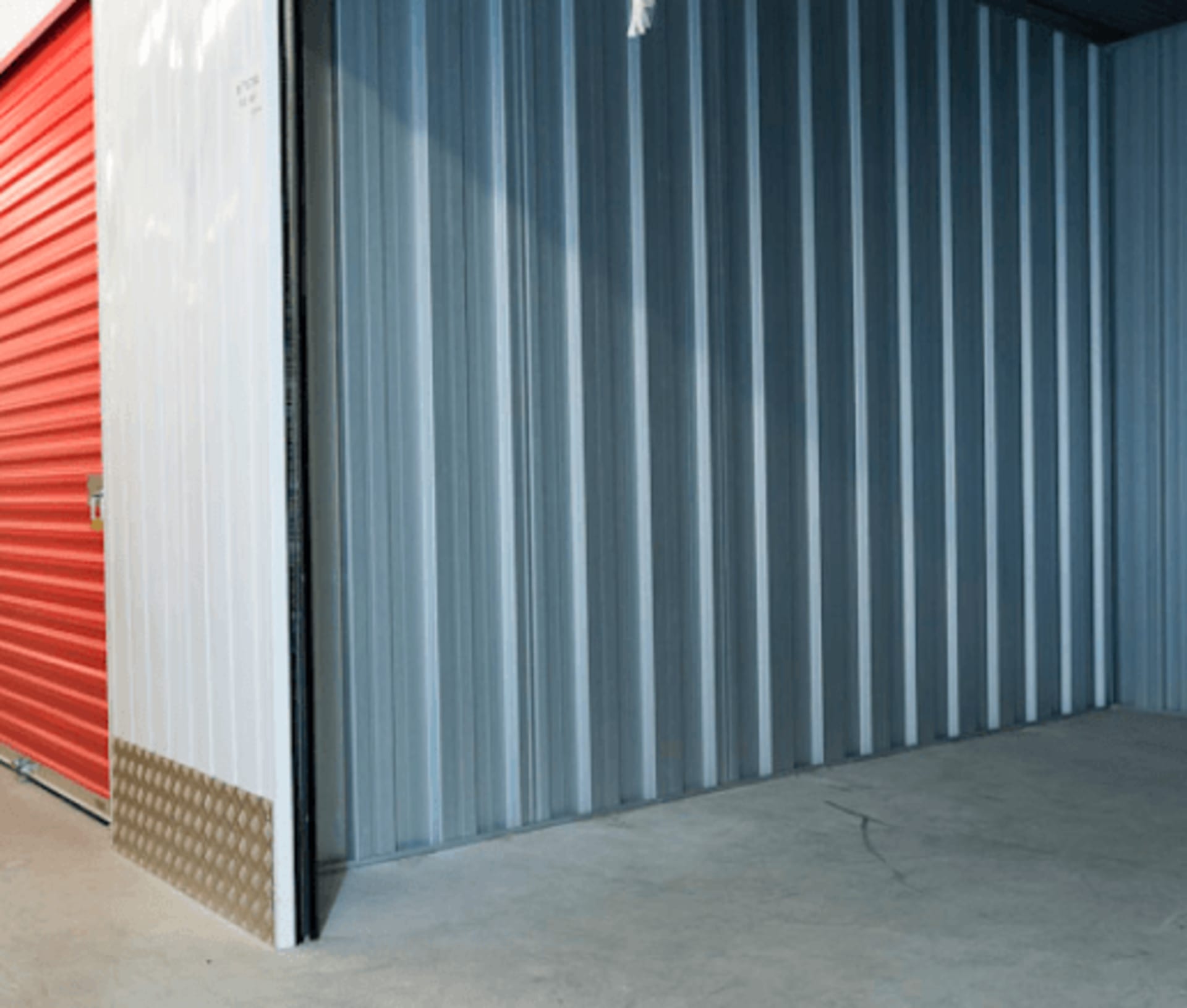 Close-up of blue and red corrugated metal storage unit doors at HOMEBOX Braga