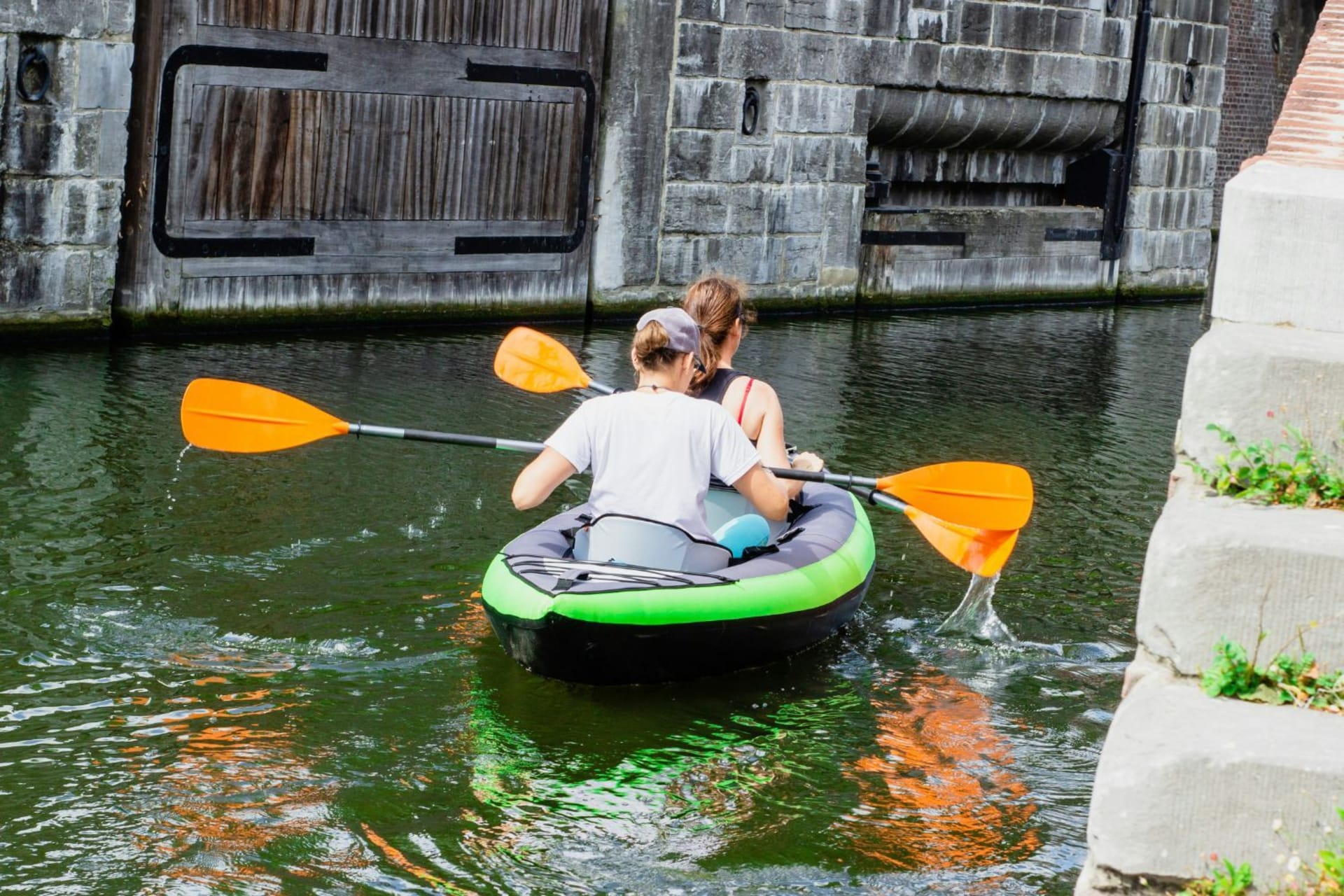 Deux personnes dans un kayak gonflable noir et vert