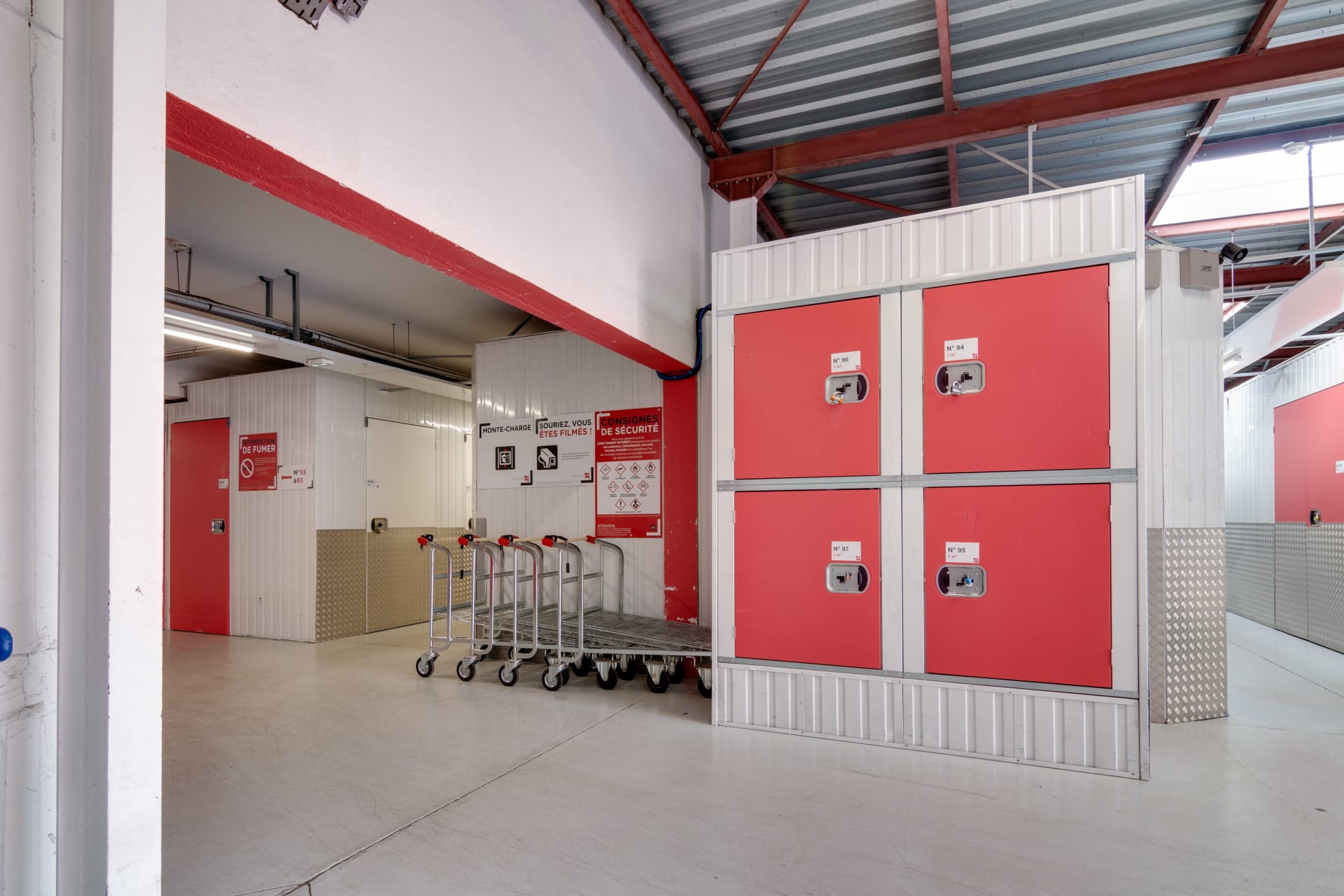 Espace intérieur avec chariots de manutention et casiers consigne rouges du centre HOMEBOX Montpellier