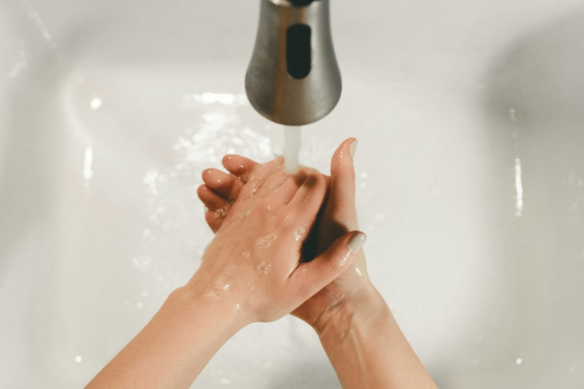 Vue sur les mains d’une personne sous un robinet