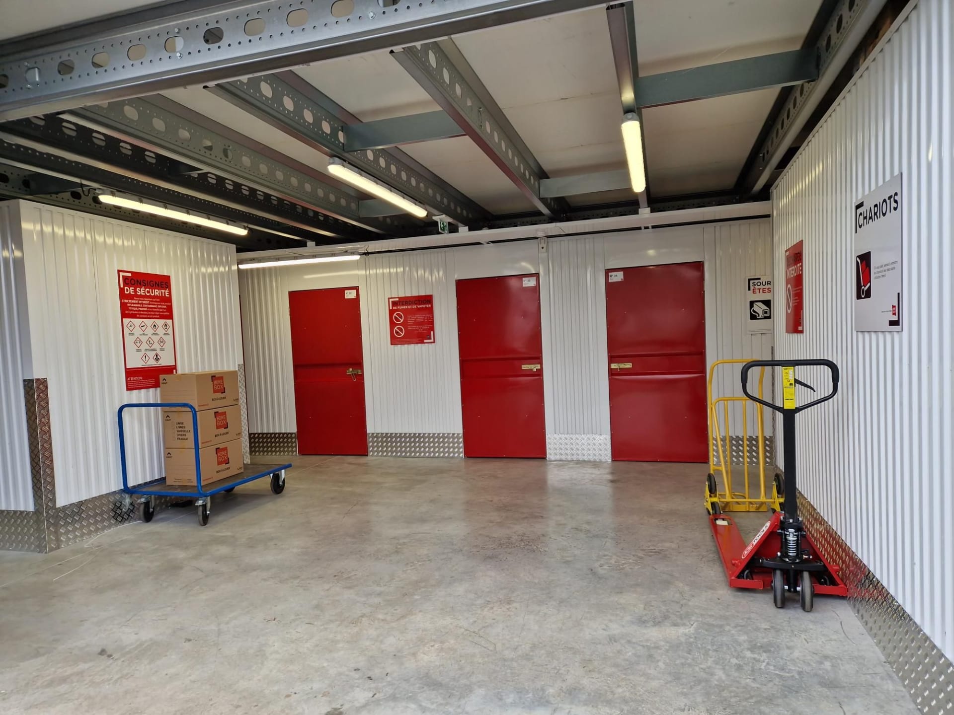 Quai de déchargement intérieur avec portes de box rouges au centre HOMEBOX Bressuire.