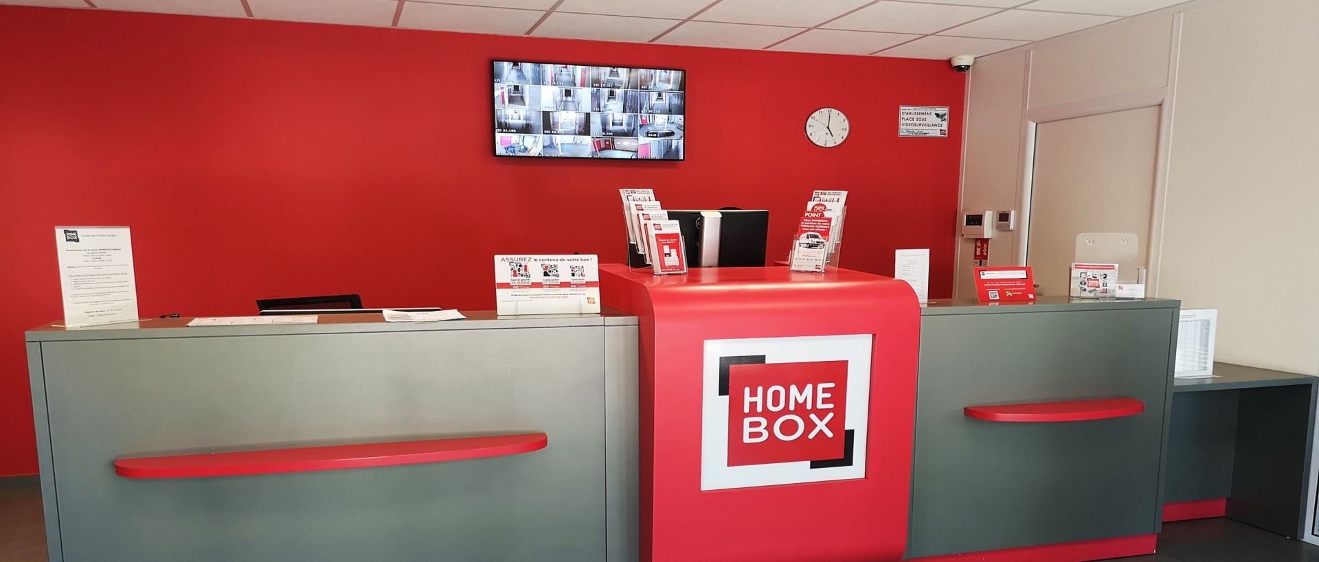 Comptoir d’accueil rouge et gris au centre HOMEBOX Caen Est.