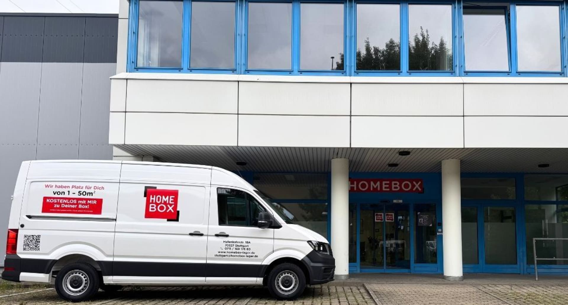 White HOMEBOX van outside blue-windowed entrance with red signage at HOMEBOX Stuttgart, Hafenbahnstr. 18A, Stuttgart