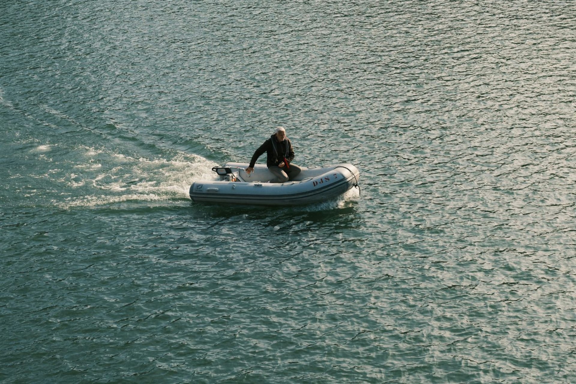 Personne sur un bateau gonflable en pleine mer en fin de journée