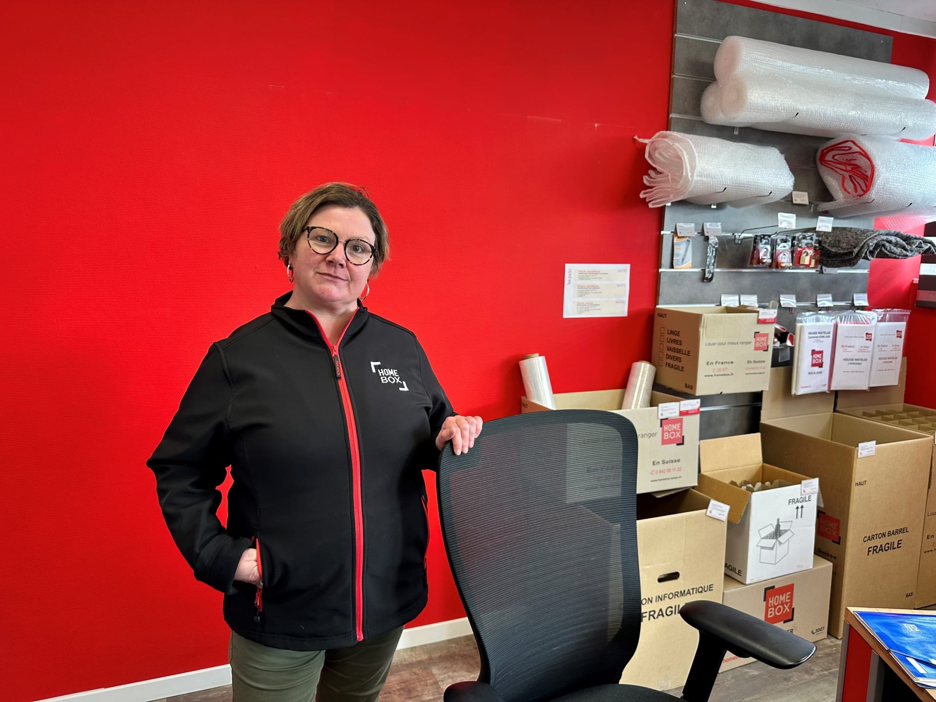 Conseillère devant le rayonnage de fournitures d'emballage du centre HOMEBOX Bayeux