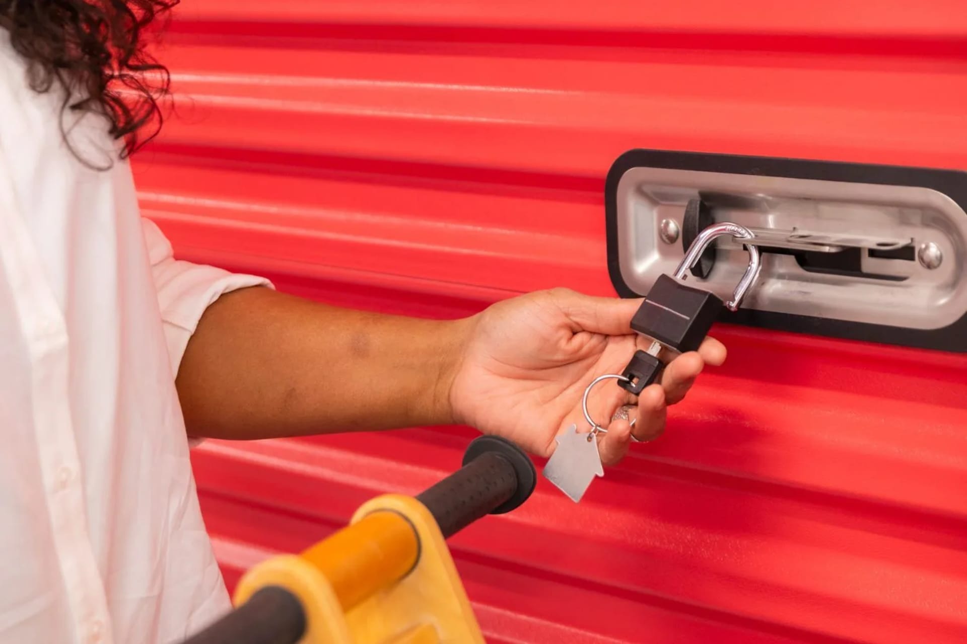 Personne fermant la porte d’un garde-meuble à l’aide d’un cadenas