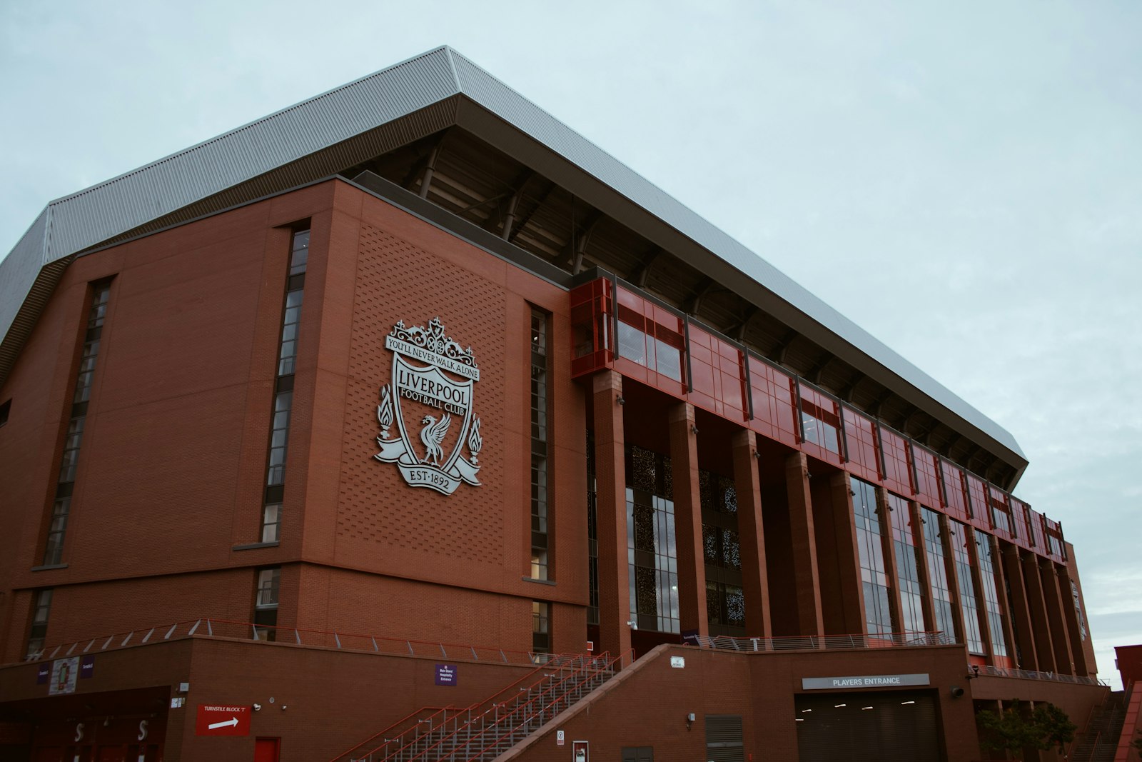 Exterior of Anfield Stadium brick building with crest