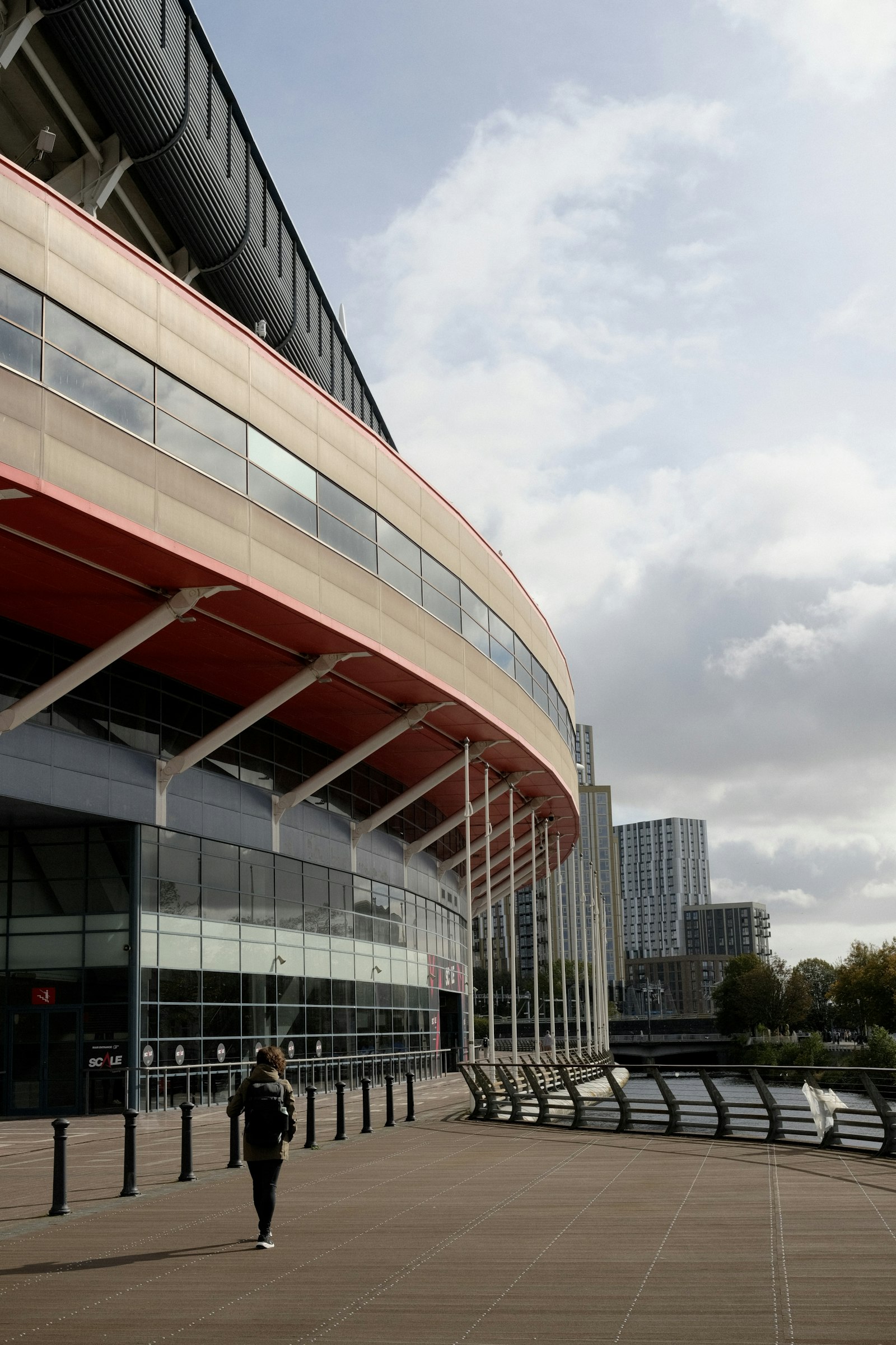 Person walking towards Anfield modern stadium building