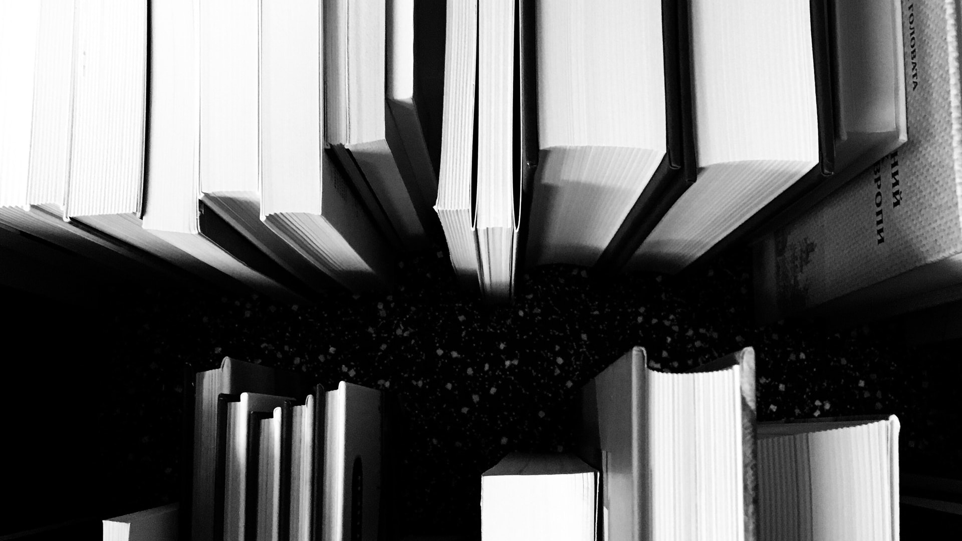 Monochromatic 45 degree angled birds eye view of books captured in shades of black and white