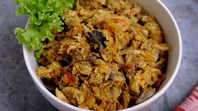 Cakalang Fufu — hidangan ikan cakalang asap khas Manado yang disajikan dengan bumbu rempah di atas piring putih dengan lalapan segar