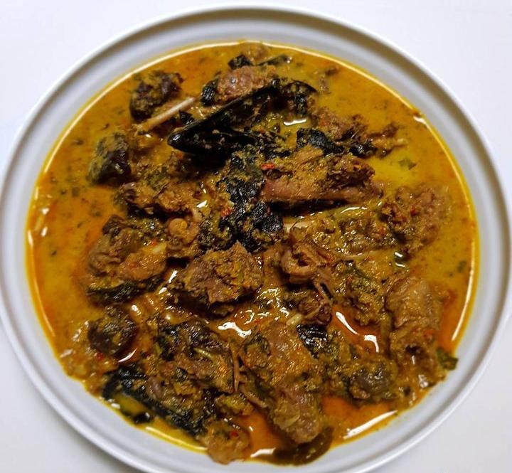 Paniki — hidangan daging kelelawar khas Manado yang dimasak dengan santan kental berwarna kuning keemasan dan bumbu rempah, disajikan di atas piring dengan lalapan segar