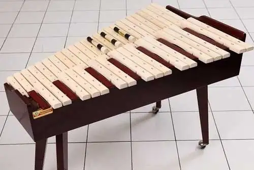 Alat musik Kolintang terbuat dari kayu dengan bilahan nada yang tersusun rapi di atas tali pengikat