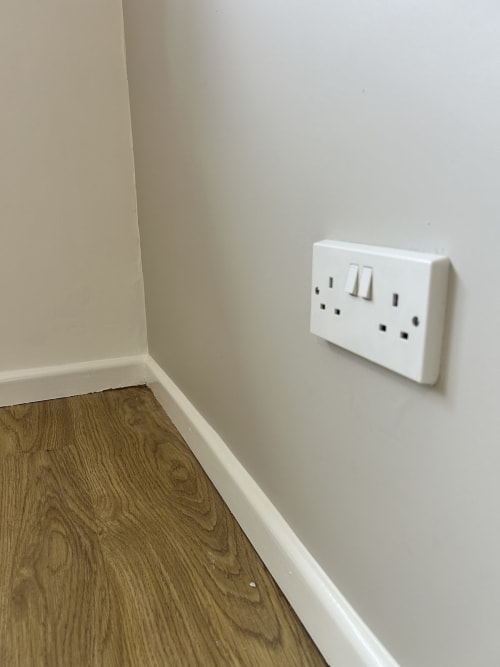 The same socket refitted on a flat painted wall with white skirting below