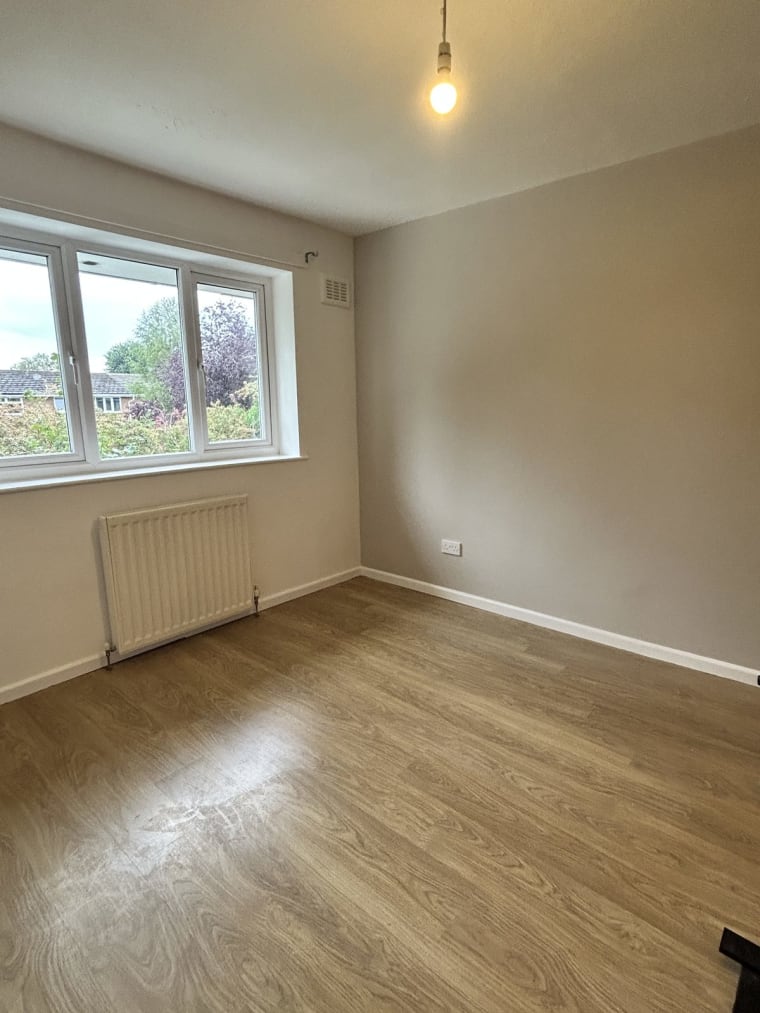The finished bedroom, empty and painted, radiator back on the wall and the floor clear
