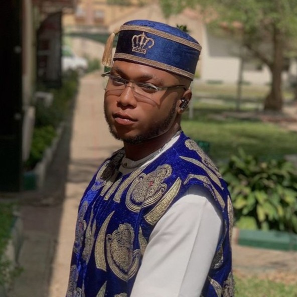 Professional portrait of African male executive in navy suit with confident smile in modern office setting