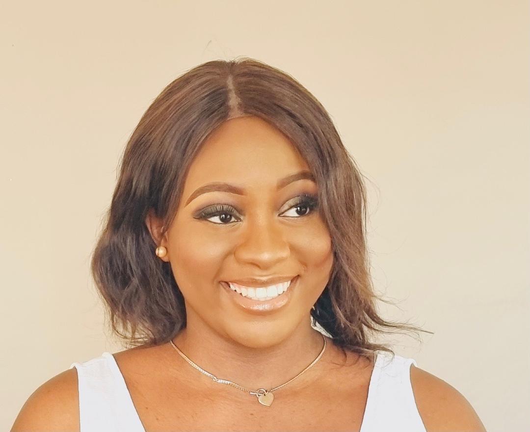 Professional headshot of African male researcher in smart casual attire with glasses in research laboratory
