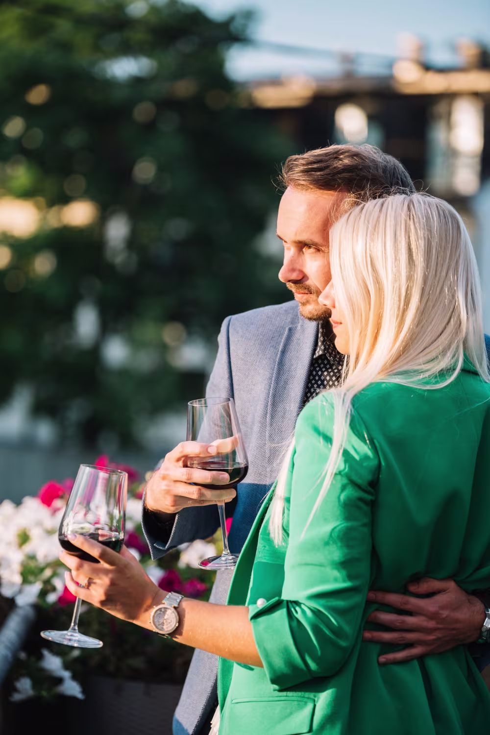 A man and a woman raising their glasses over a meal