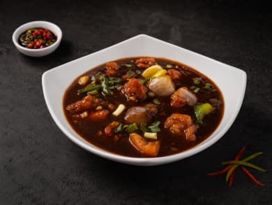 A steaming bowl of Vietnamese beef pho garnished with fresh herbs