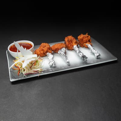 Xin Chicken Lollipop — Indo-Chinese frenched chicken drumettes, chilli-garlic glaze, spring onion garnish