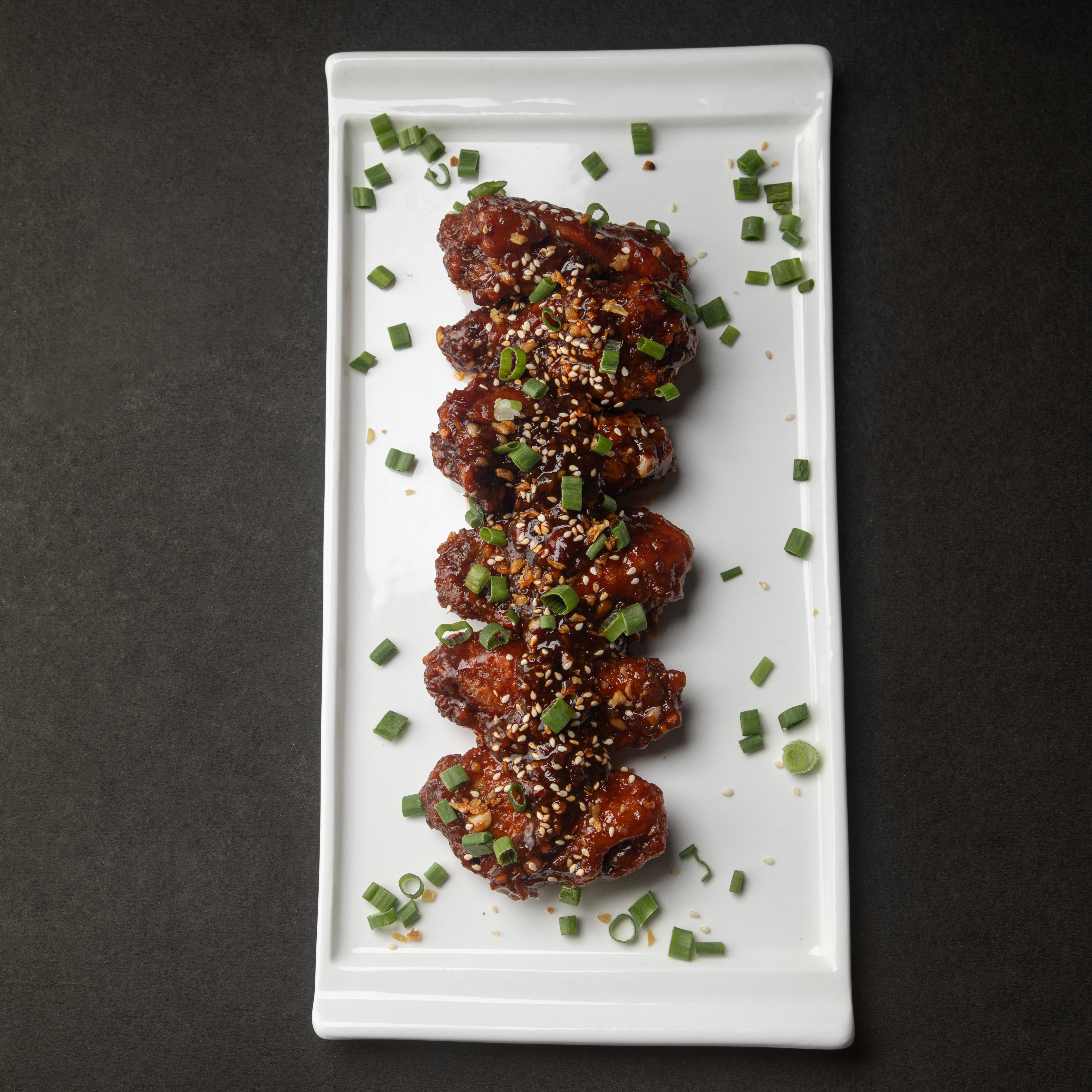 Xin Asian Chicken Wings — twice-fried, glazed with soy-honey and toasted sesame, served with pickled slaw