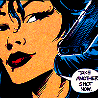 Screenshot from The Question Annual 1. Close-up to Shiva's amused expression. She's holding a gun close to her face, and says "Take another shot now." before giving it to her oponent.