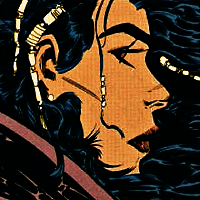 Screenshot from The Question issue 29. Close up to Shiva's profile. Her hair is flowing around her face, in the wind, and she wears various yellow beads adoring it. The neckline of her purple coat is visible. She wears a serious expression.