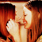 Tara and Willow's profiles, facing each other. Tara's hand brushes WIllow's hair; Tara smiles, and they have their eyes closes, noses touching, about to kiss.