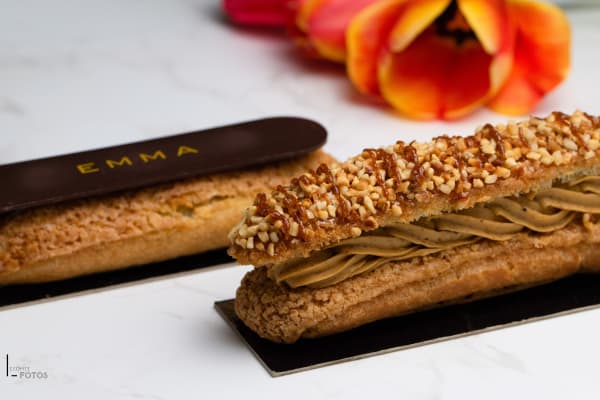 Éclair praliné garni de crème et nappé de noisettes caramélisées, présenté avec un éclair signé EMMA, pâtisserie photographiée par Delphine Lecomte à Nantes
