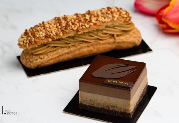Entremets trois chocolats décoré d'une plaque EMMA accompagné d'un éclair praliné aux noisettes, créations de la Pâtisserie Emma
