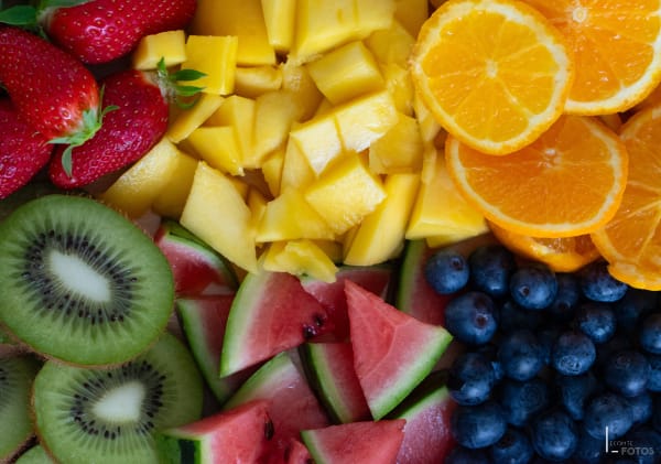 Composition de fruits frais découpés vue de dessus — fraises, kiwis, mangue, oranges, pastèque et myrtilles — photographie culinaire à Nantes