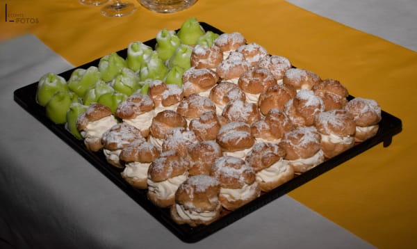 Plateau de choux à la crème saupoudrés de sucre glace accompagnés de raisins verts, buffet sucré traiteur