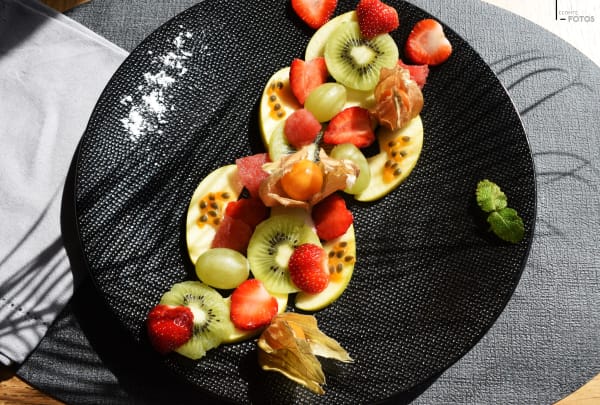 Assiette noire mettant en valeur la fraîcheur de fruits coupés