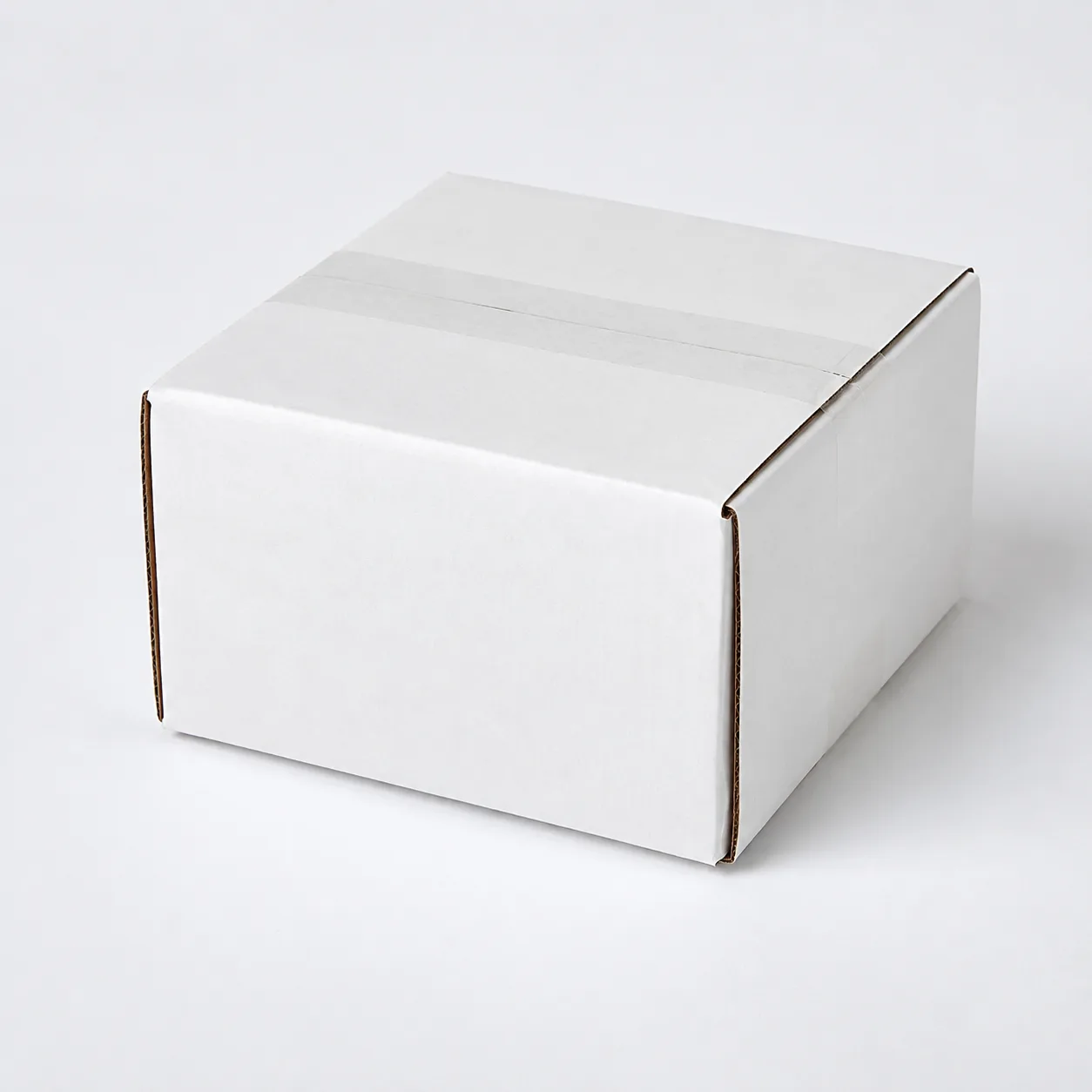 Close-up view of white corrugated carton material and tape area