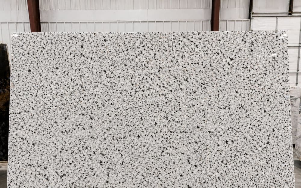 Bianco Crystal granite — polished slab surface showing White coloring. Origin: India. Hardness: 6 Mohs. Acid sensitivity: none.