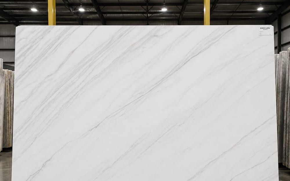 Bianco Lassa marble — polished slab surface showing White coloring. Origin: Italy (Apuan Alps). Hardness: 3 Mohs. Acid sensitivity: high.