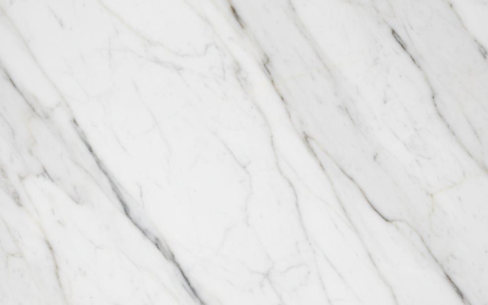 Calacatta Cremo marble — polished slab surface showing White coloring. Origin: Italy (Carrara). Hardness: 3 Mohs. Acid sensitivity: high.