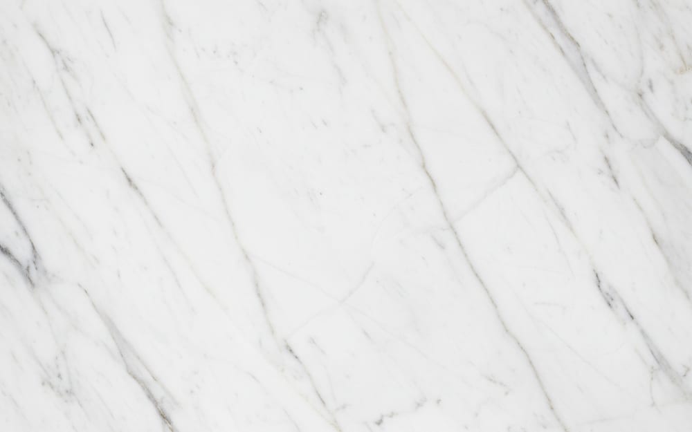 Elegant White marble — polished slab surface showing White coloring. Origin: Italy / Turkey. Hardness: 3 Mohs. Acid sensitivity: high.