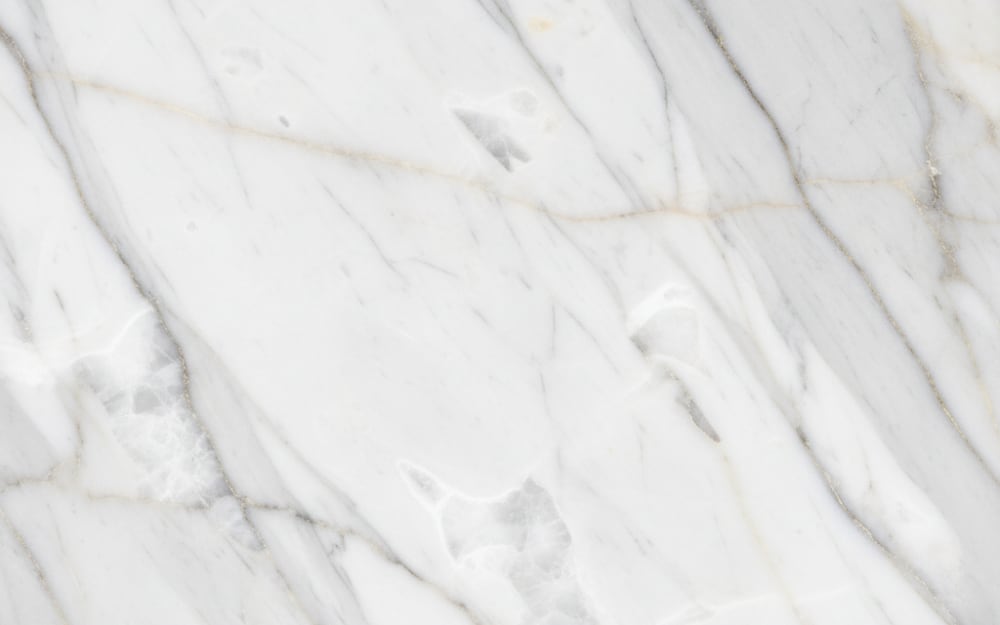 Gris Pulpis marble — polished slab surface showing White coloring. Origin: Spain (Castellón). Hardness: 3 Mohs. Acid sensitivity: high.