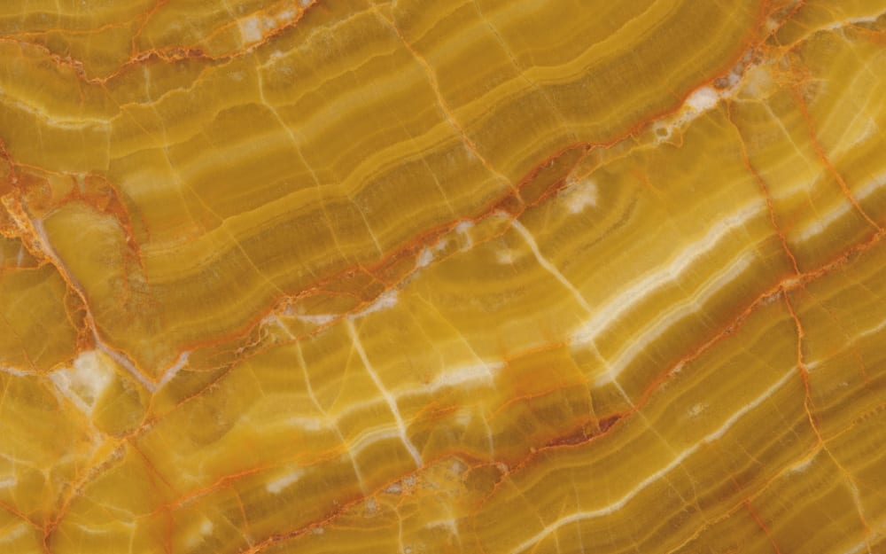 Honey Onyx Marble marble — polished slab surface showing Gold/Yellow coloring. Origin: Turkey. Hardness: 3 Mohs. Acid sensitivity: high.