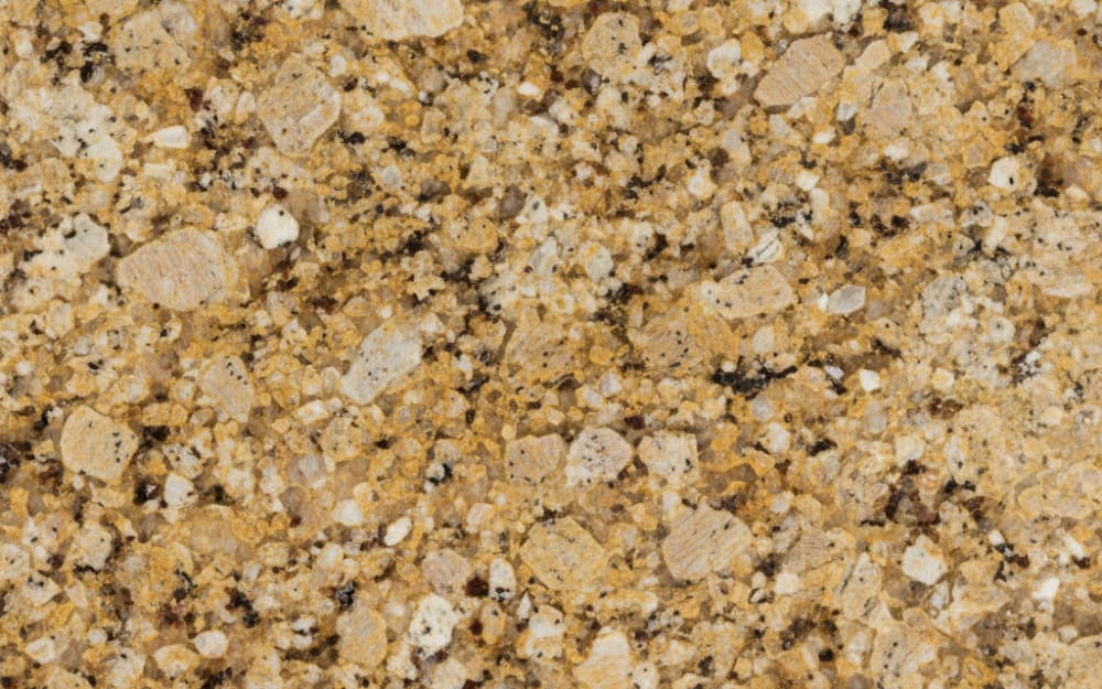 New Venetian Gold granite — polished slab surface showing Gold/Yellow coloring. Origin: Brazil. Hardness: 6 Mohs. Acid sensitivity: none.