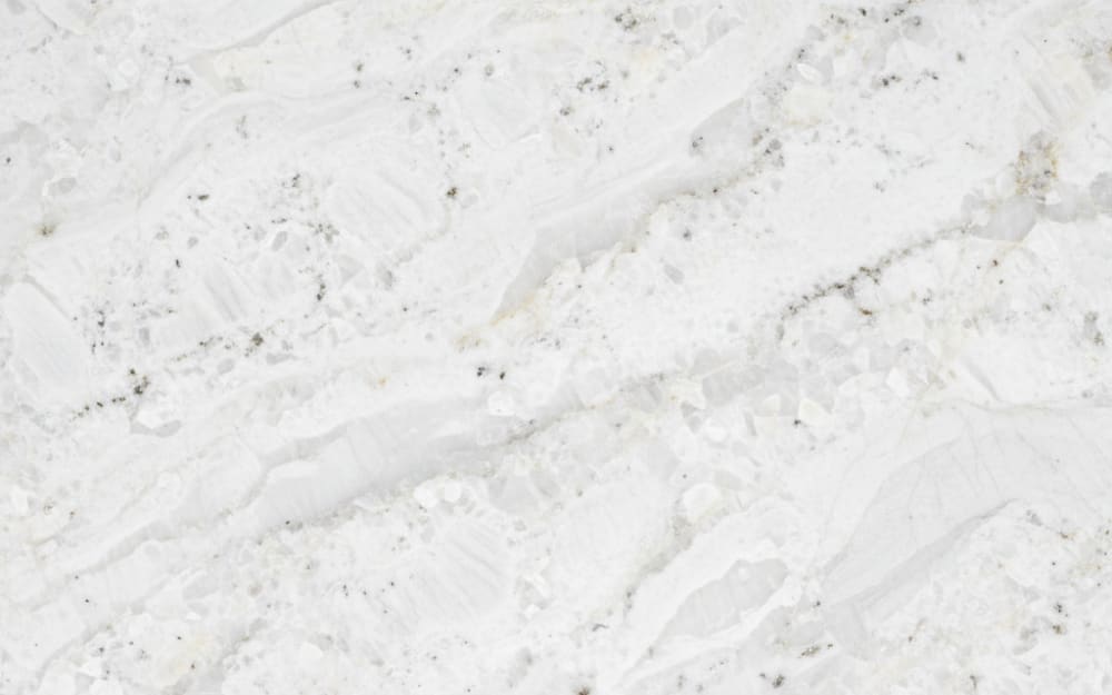 Snow Flurry granite — polished slab surface showing White coloring. Origin: Brazil. Hardness: 6 Mohs. Acid sensitivity: none.