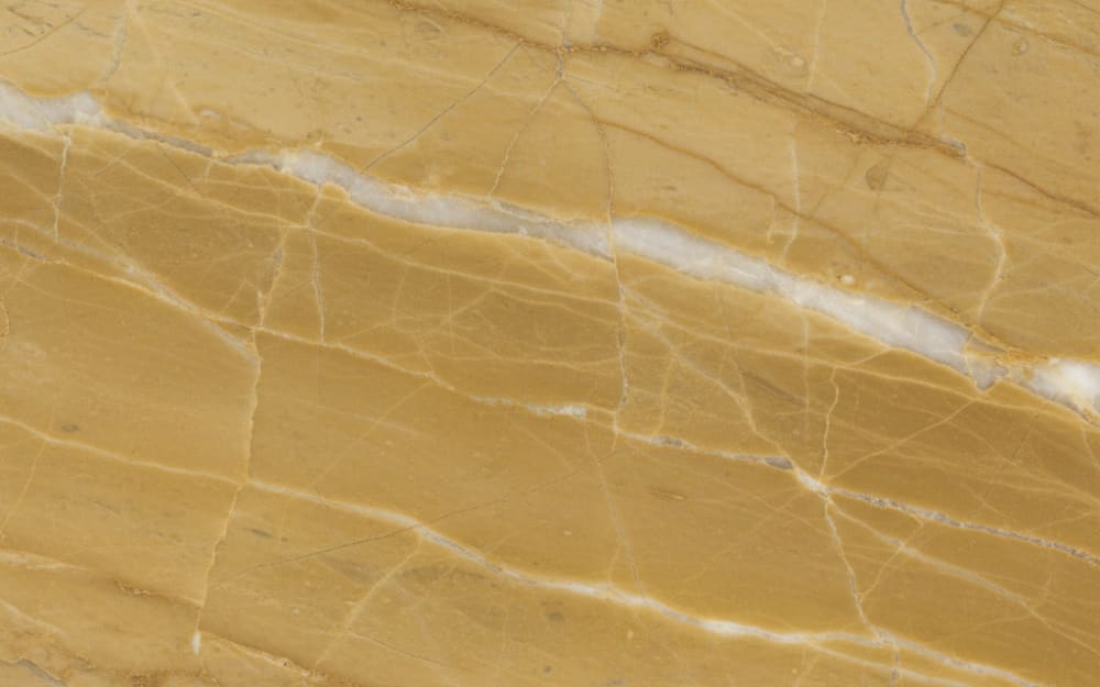 Spanish Gold marble — polished slab surface showing Gold/Yellow coloring. Origin: Spain. Hardness: 3 Mohs. Acid sensitivity: high.