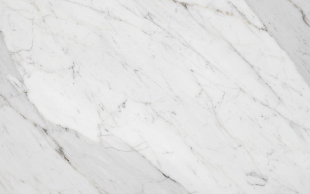 Statuarietto marble — polished slab surface showing White coloring. Origin: Italy (Carrara). Hardness: 3 Mohs. Acid sensitivity: high.